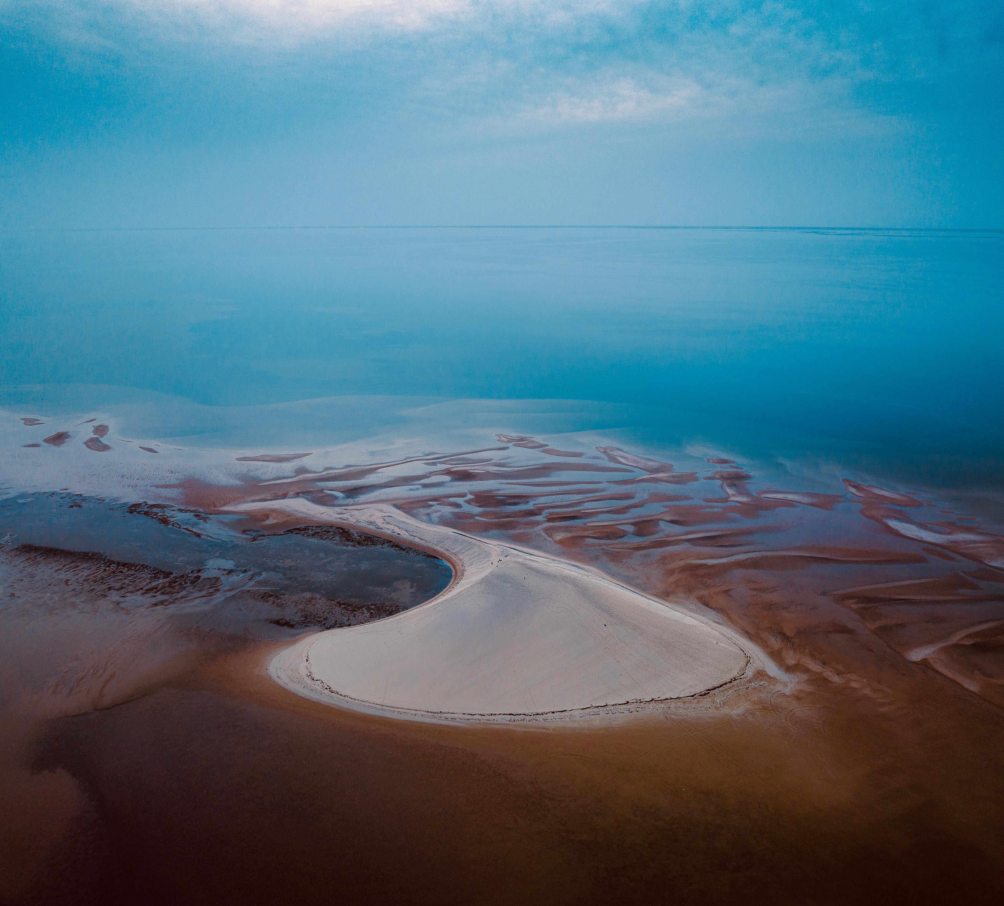 Pristine white sand dunes meeting turquoise lagoon waters at a secluded kite spot in Dakhla